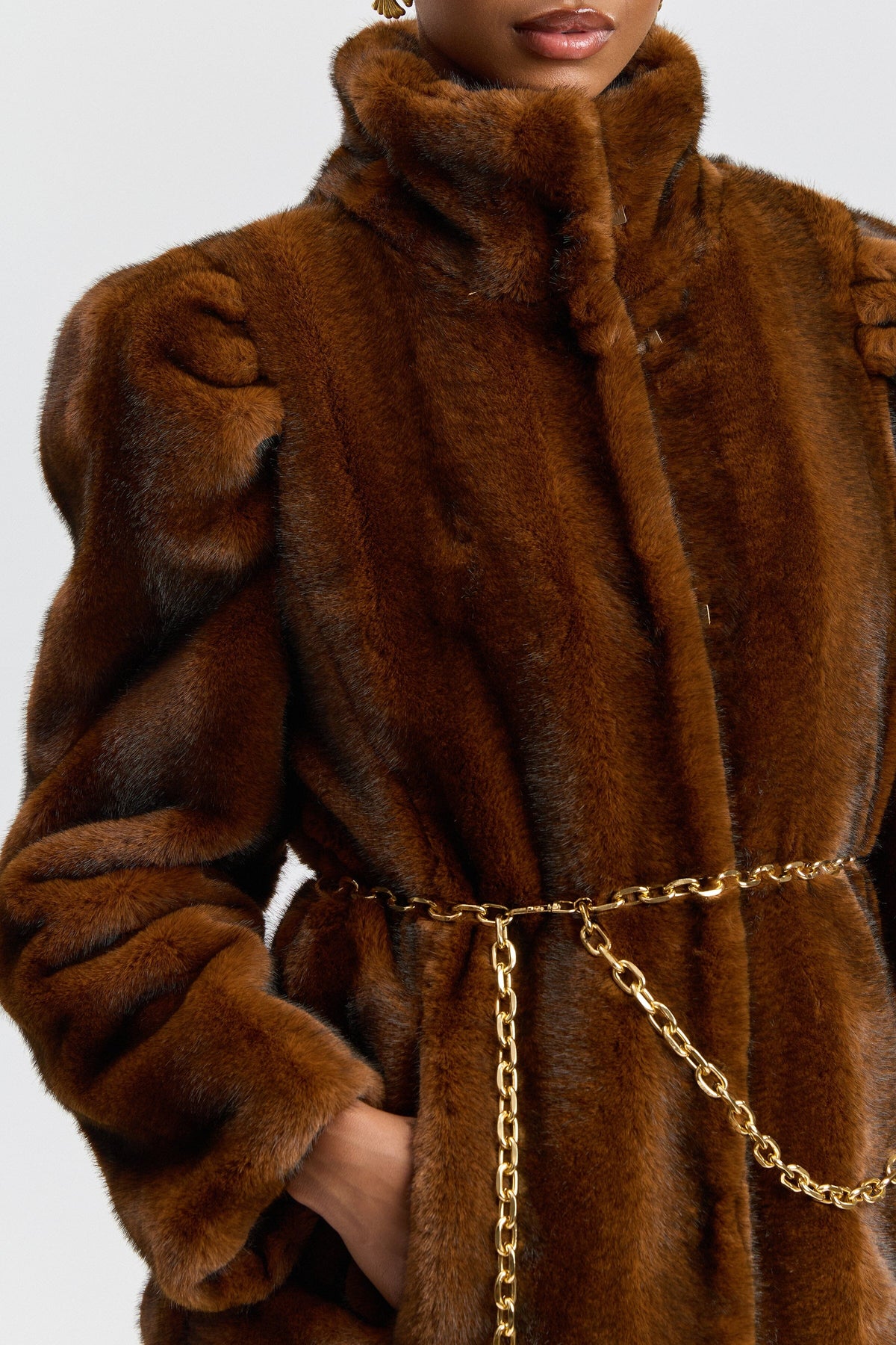 Puff-sleeve brown faux fur coat with a chain belt and stand collar. Shop cute faux fur jackets by Avec Les Filles.