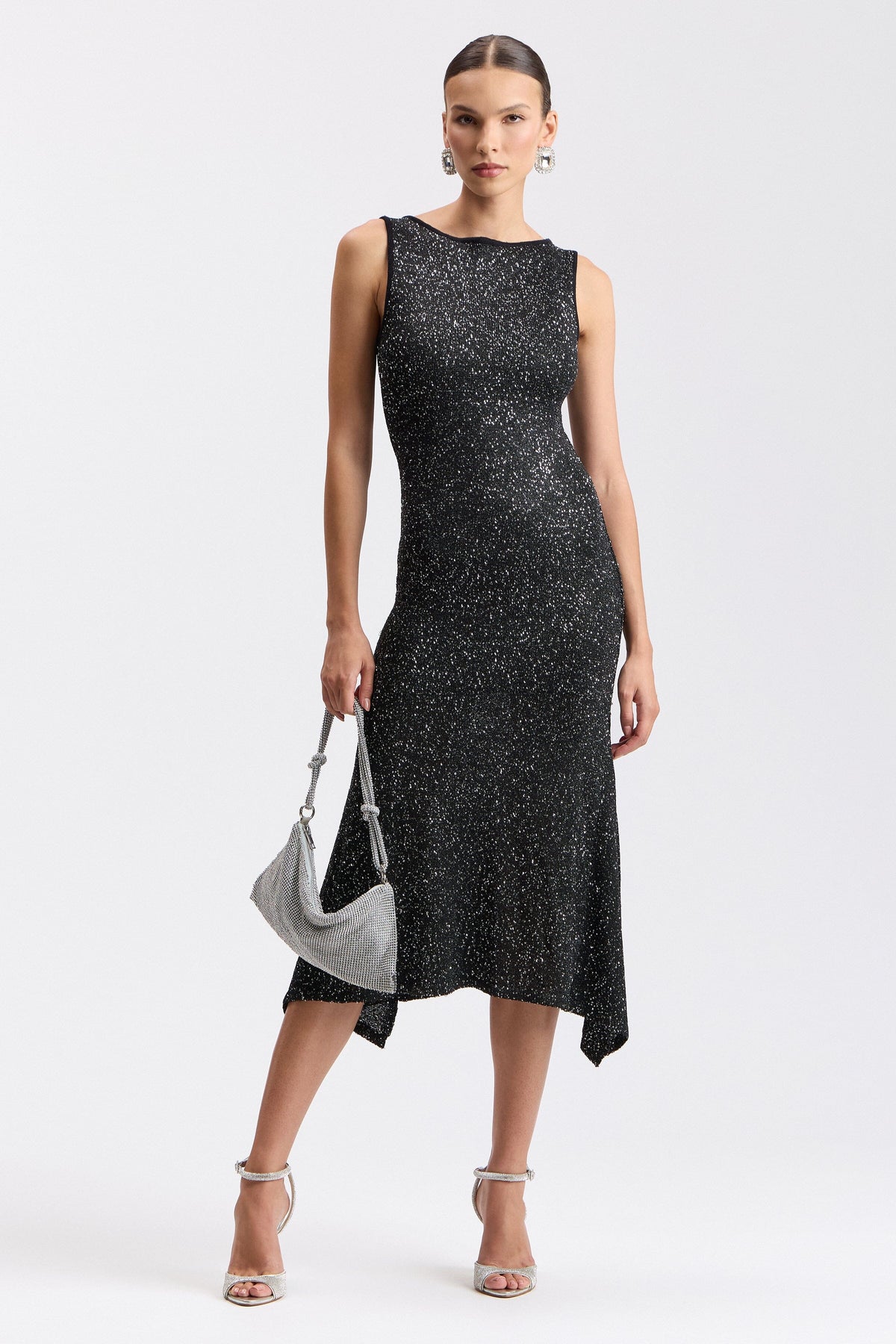 Black sequin sweater dress with boat neck and asymmetric hem. Shop evening midi dresses by Avec Les Filles.