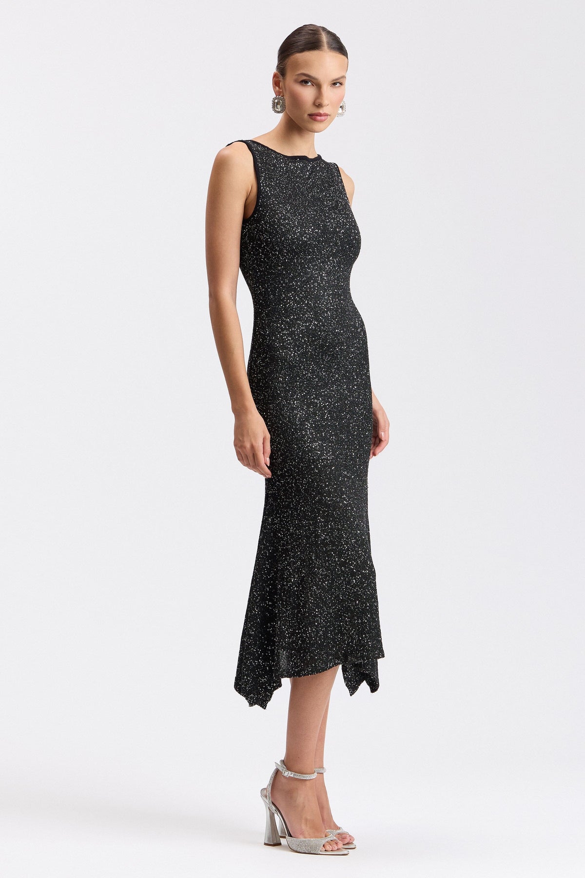 Black sequin sweater dress with boat neck and asymmetric hem. Shop evening midi dresses by Avec Les Filles.