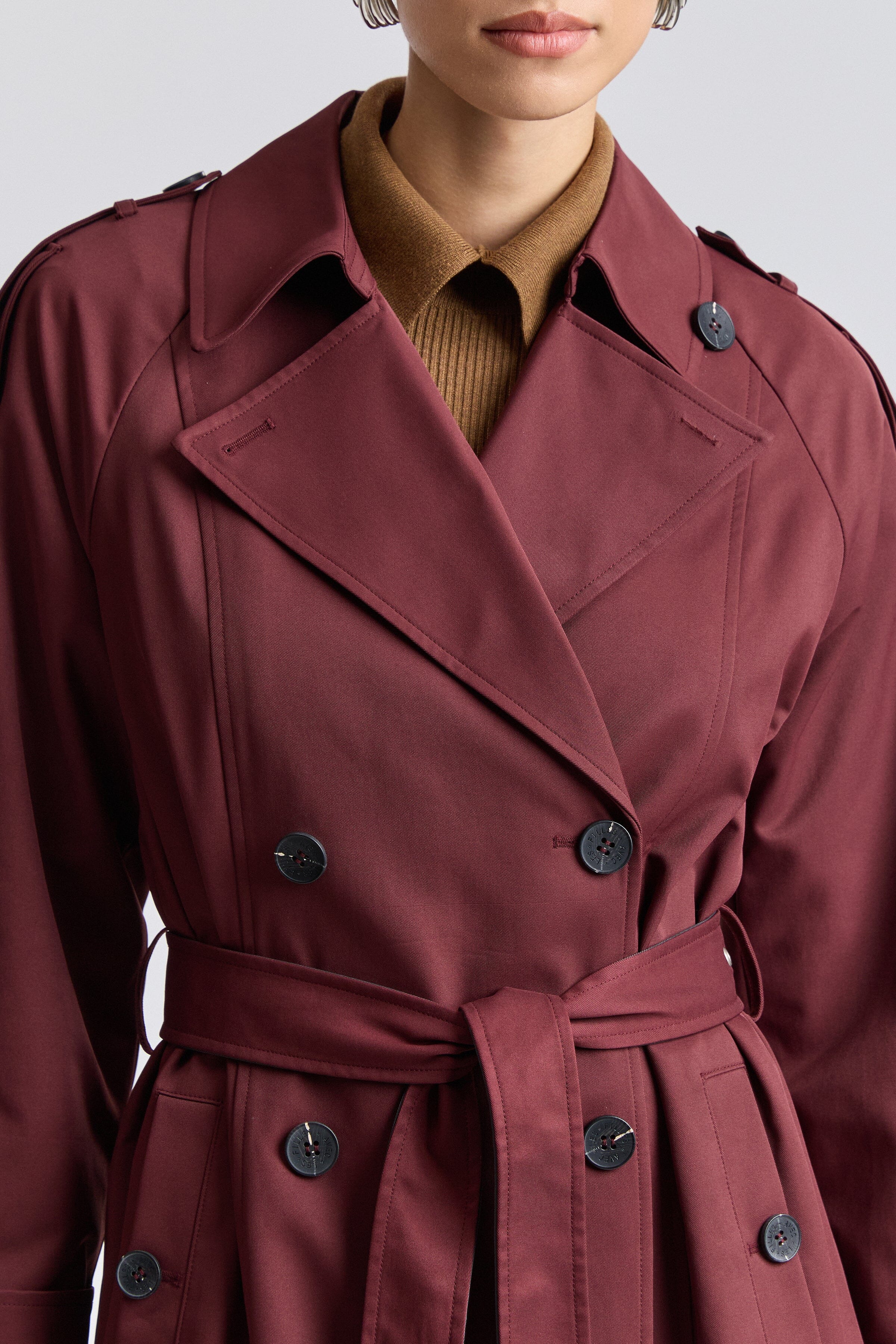 Double-breasted button-front red long trench coat with long raglan sleeves and belted waist by Avec Les Filles.