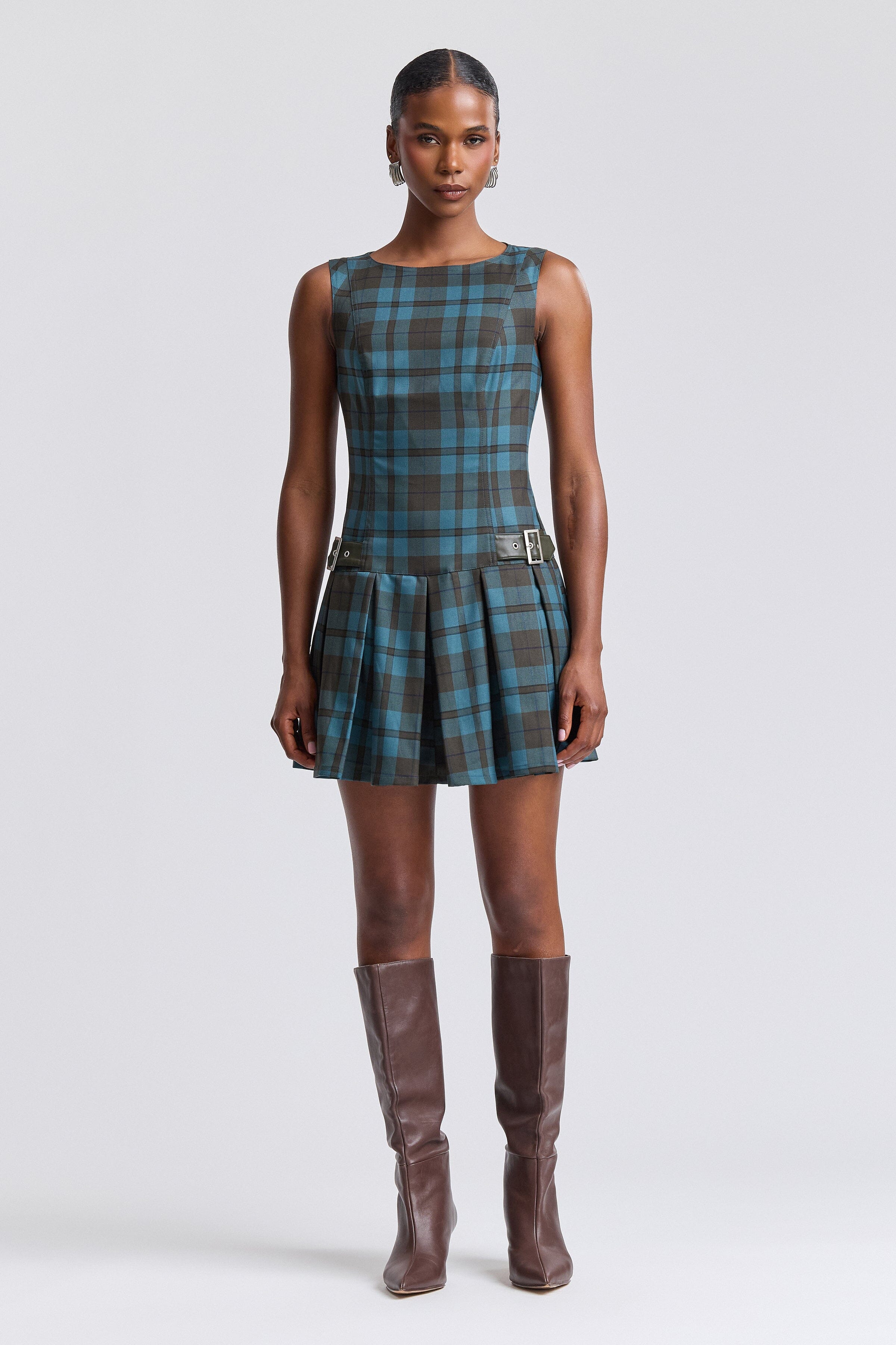 Blue sleeveless plaid mini dress with pleated drop-waist and boat neckline. Shop cute mini dresses by Avec Les Filles.