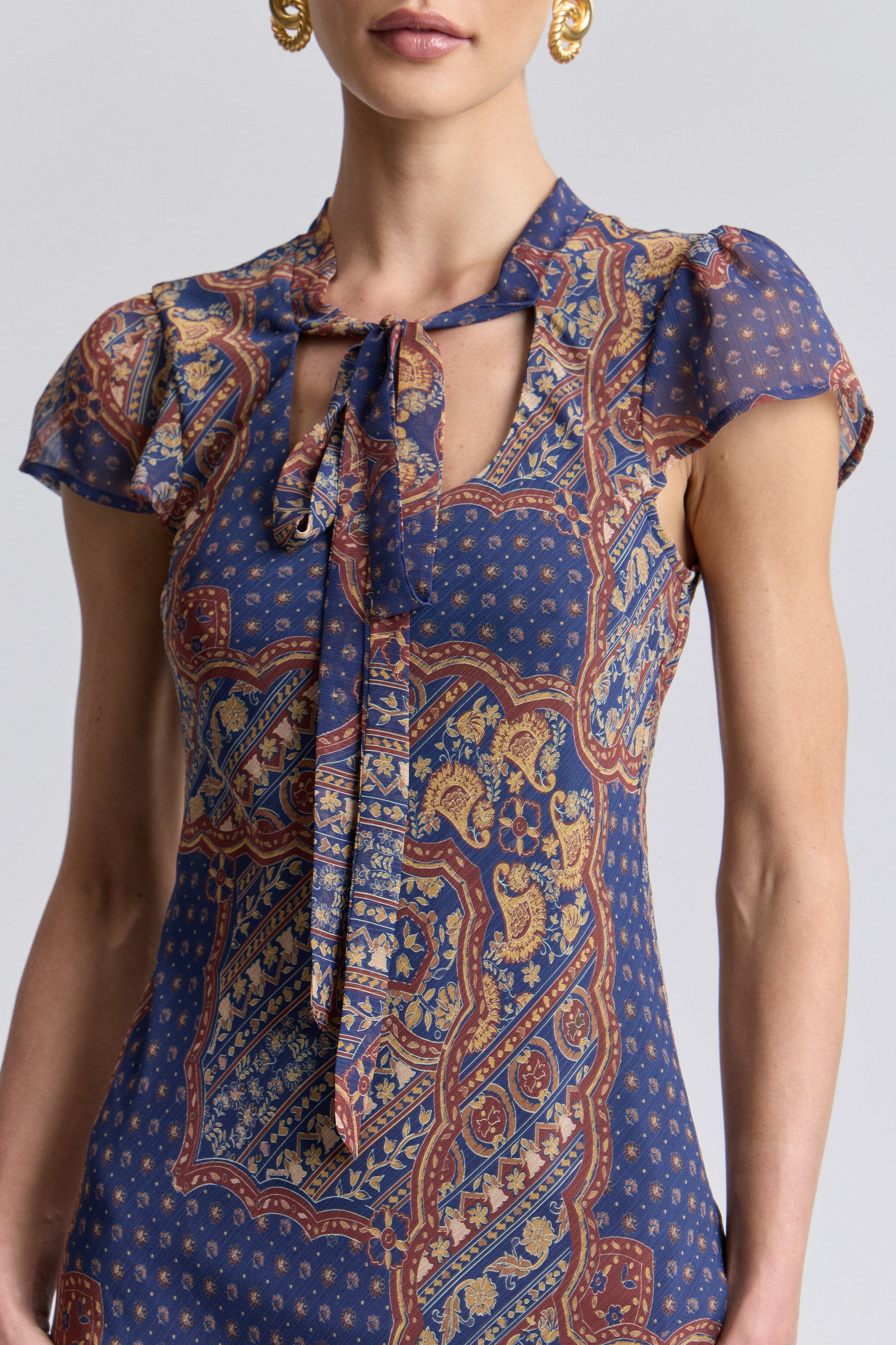 Mermaid multicolor paisley maxi dress chiffon with front-tie neckline and short flutter sleeves by Avec Les Filles.