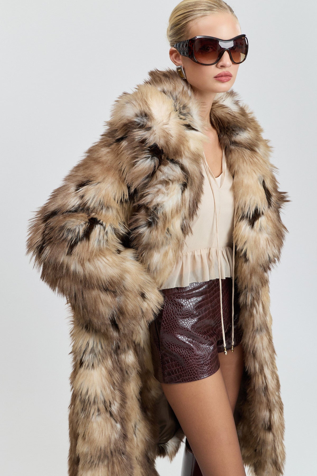 Brown long faux fur coat women with side slits and a wide collar. Shop designer tan fur coats by Avec Les Filles.