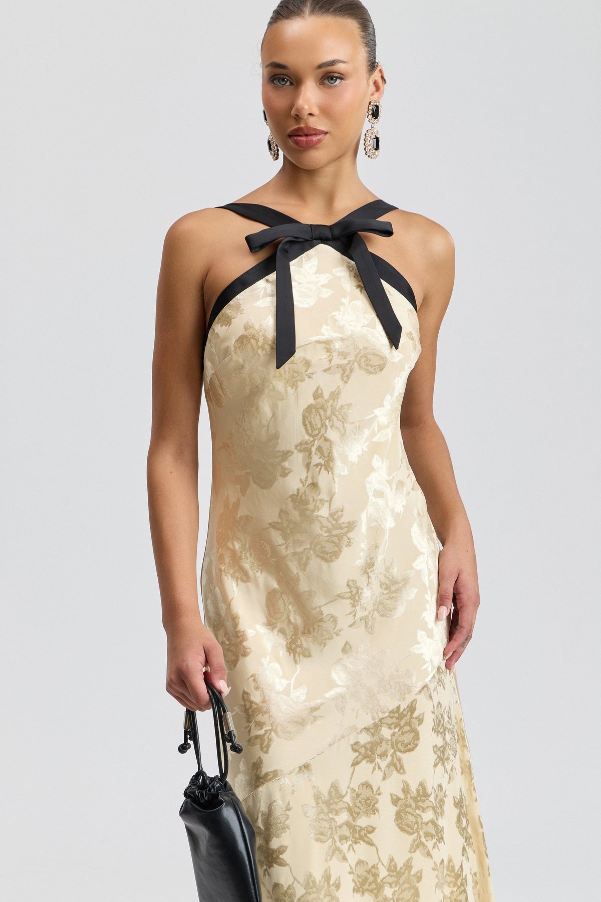 Cream halter maxi dress with black satin straps and a bow neck. Shop women's cute backless dresses by Avec Les Filles.